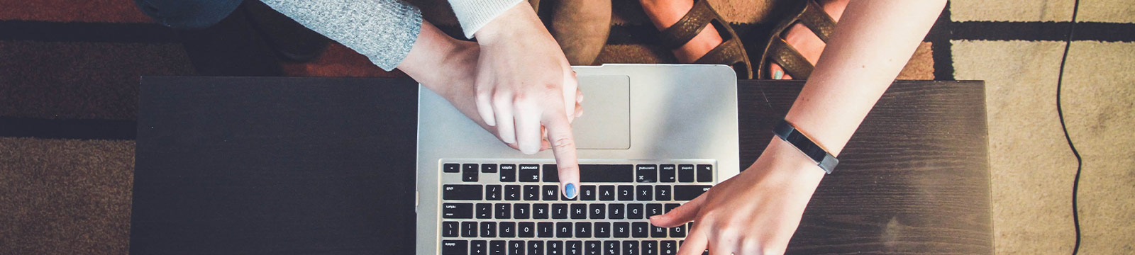 Group pointing at a laptop.