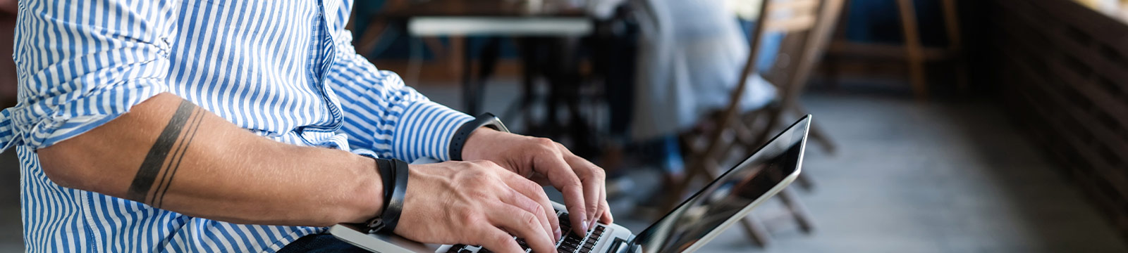 Guy with tattoo on laptop.