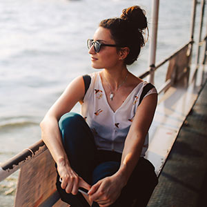 Woman sitting by the water on a ferry.