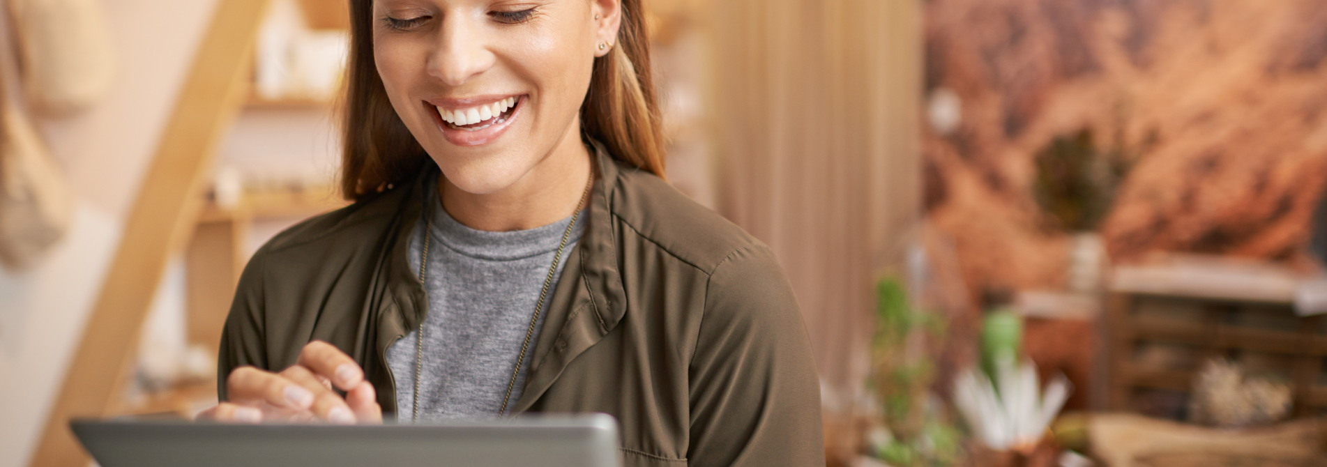 A woman smiling while on a smart device.
