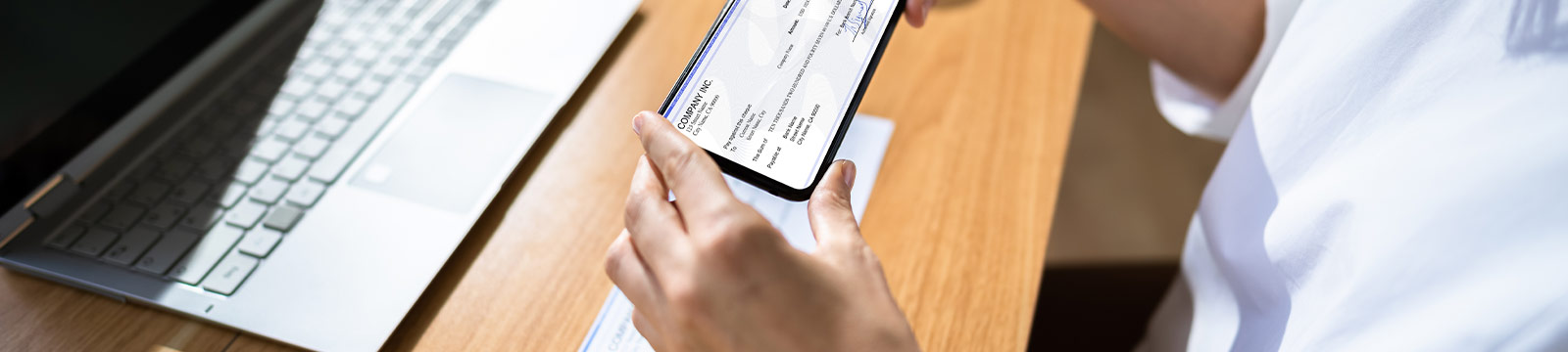 Women taking a picture of a check.